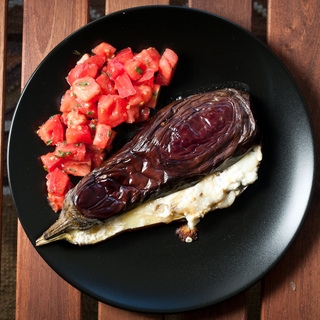 Kepti baklažanai su česnako-medaus padažu, ožkos sūriu ir pomidorų salotomis
